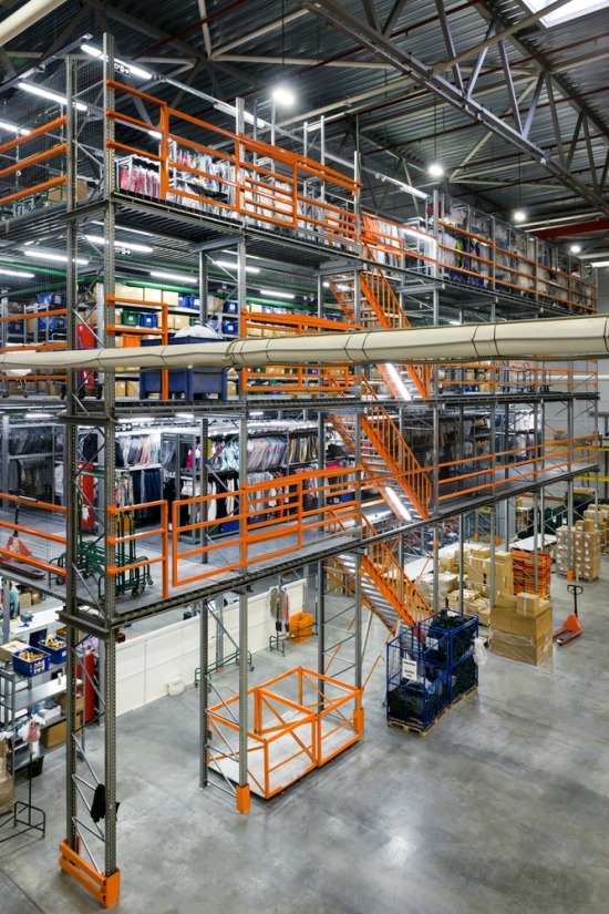 a multi tiered mezzanine floor being used for logistics and product storage in a warehouse